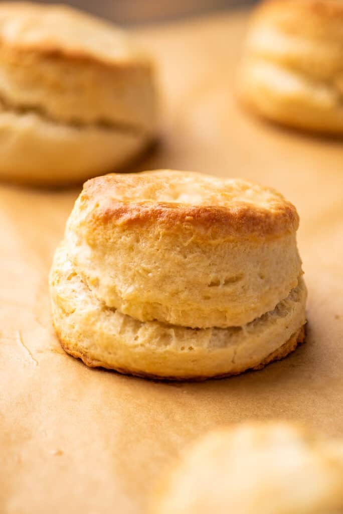 Cream biscuit sitting on parchment paper.
