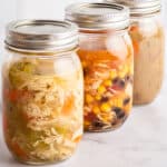 Mason jars of soup ready to be frozen.