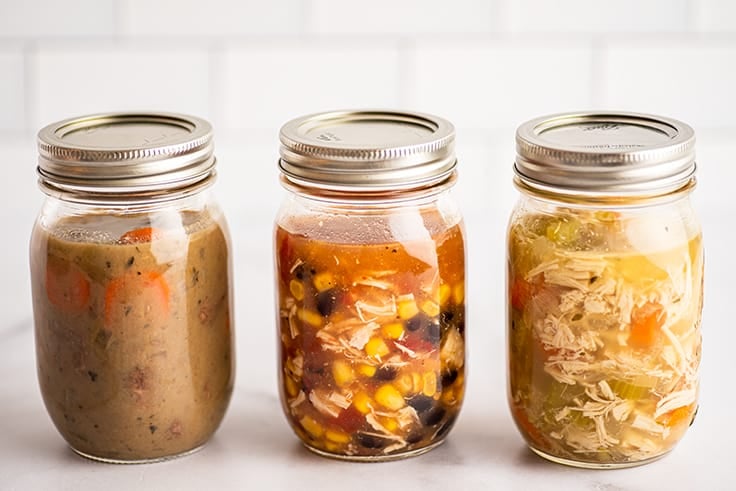 Mason jars of soup on a counter ready to be frozen.
