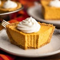 Slice of no-bake pumpkin cheesecake with a bite out of it.