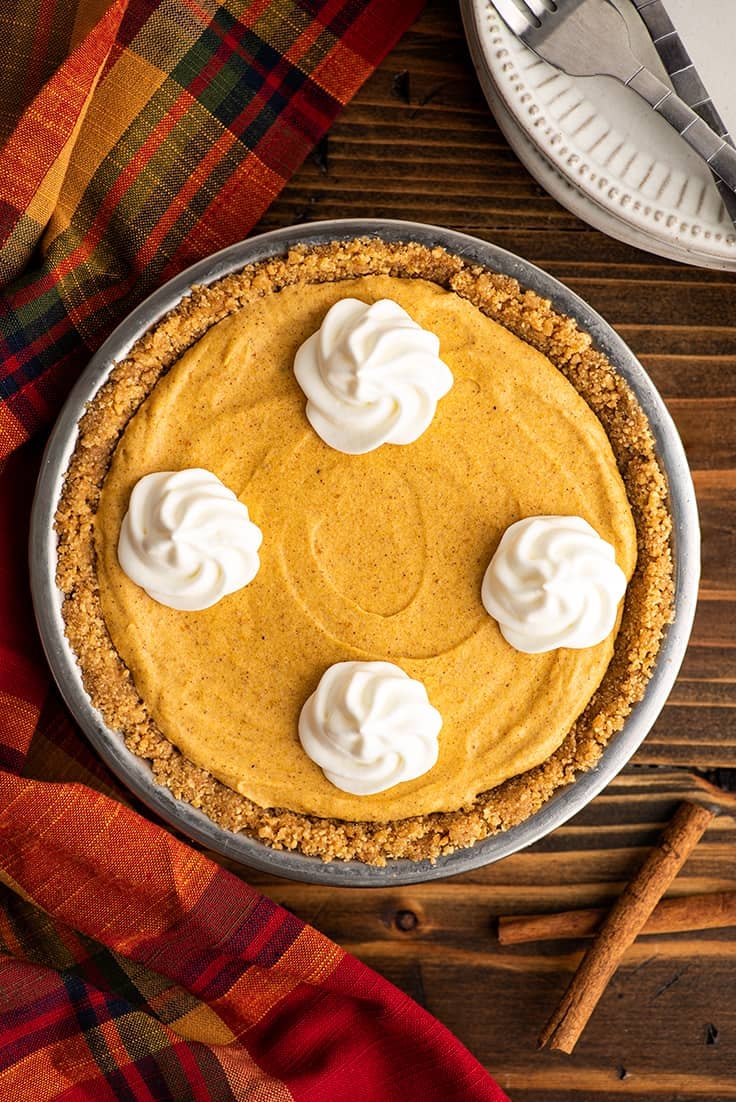 Small marshmallow pumpkin cheesecake on a wooden table.
