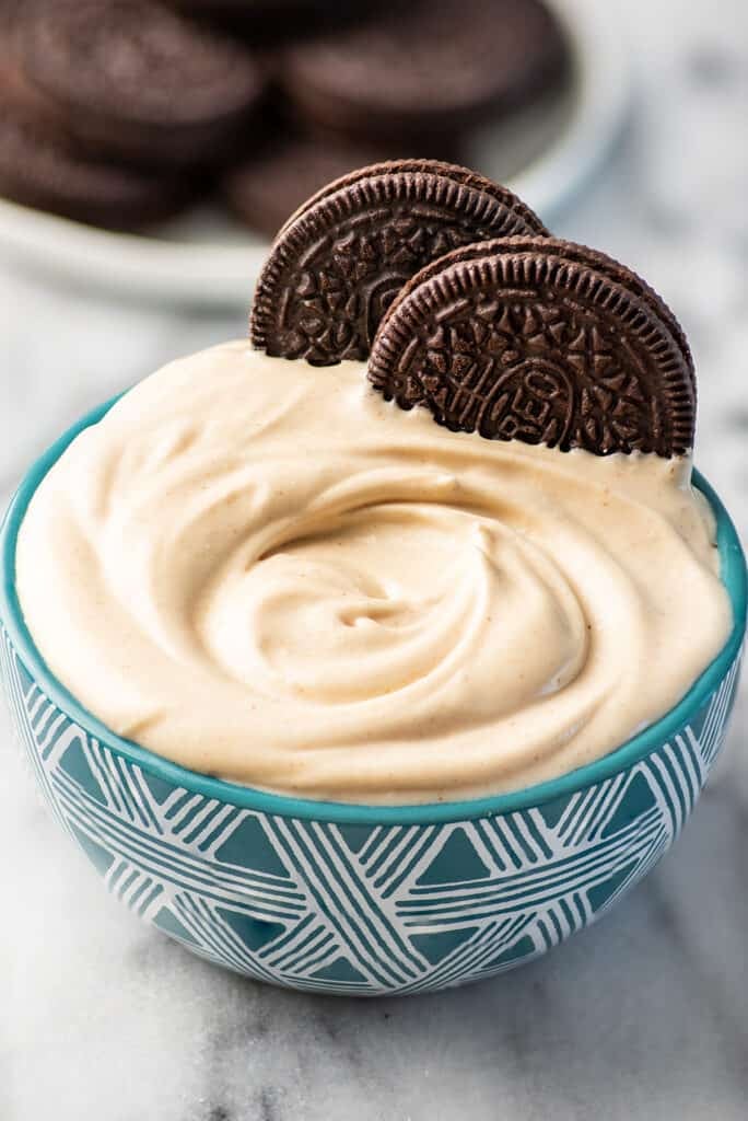 Peanut butter whipped cream in a blue bowl with Oreos.