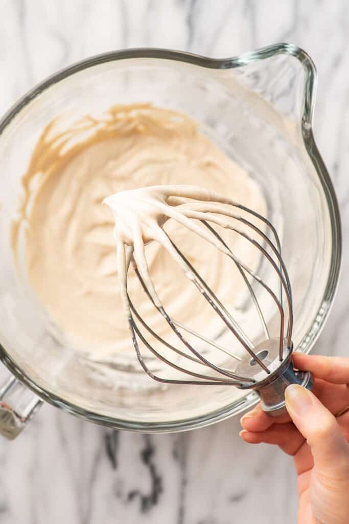 Peanut butter whipped cream on a stand mixer whisk.