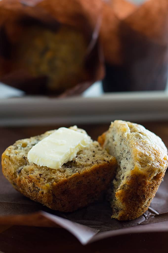 Small-batch banana muffins split open with butter on top.