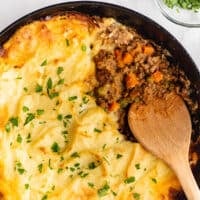 Cottage pie with ground beef filling in a cast iron pan.