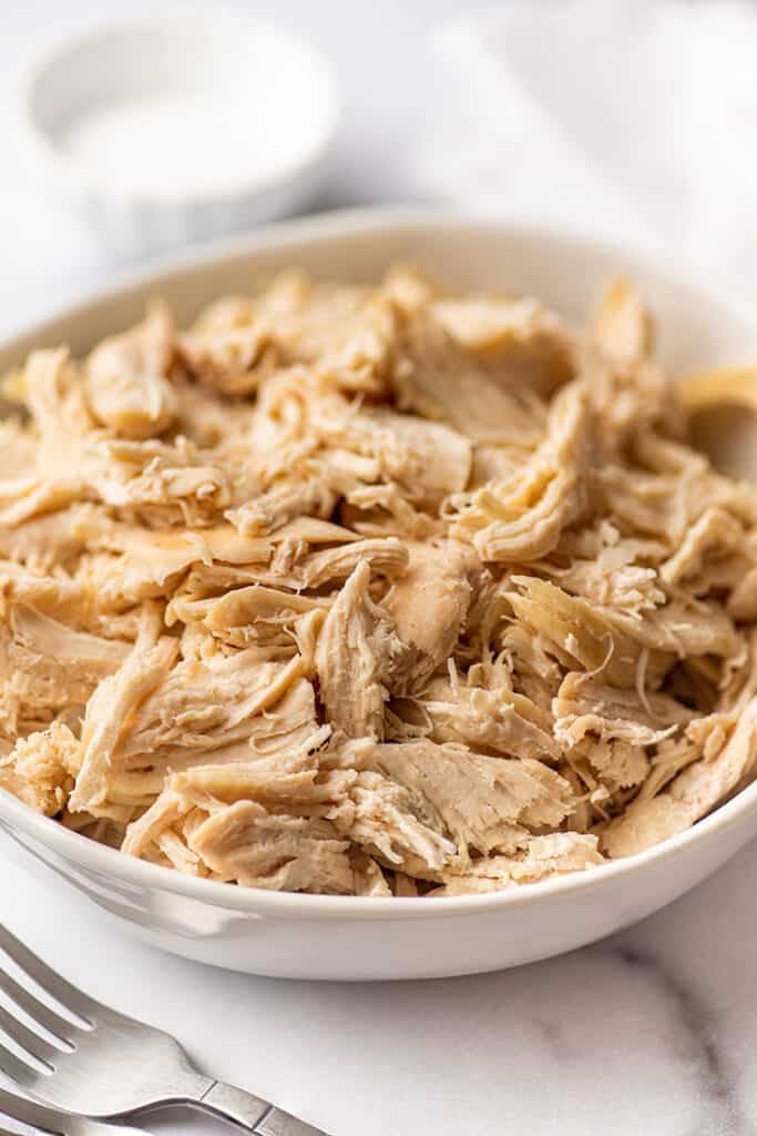 Shredded chicken for recipes in a white bowl.