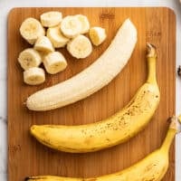 Bananas on a cutting board being prepped for freezing.