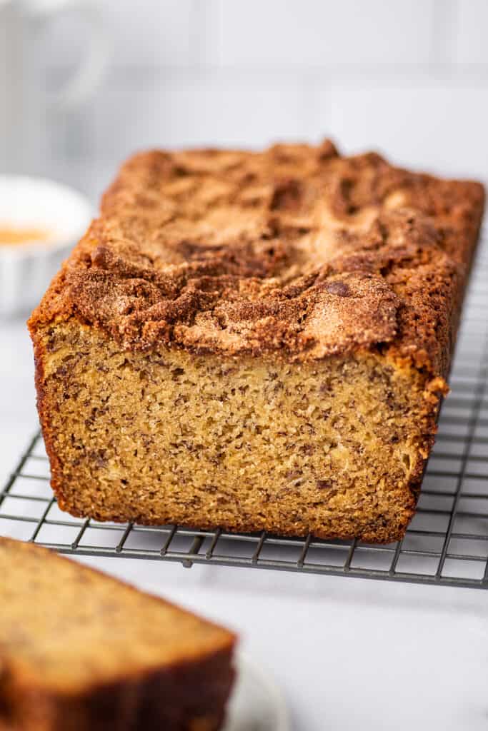 Loaf of banana bread on a wire cooling rack.