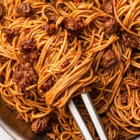 close up shot of a bolognese with some bolognese wrapped around tongs