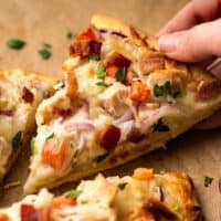 Slice of chicken bacon ranch pizza being picked up.