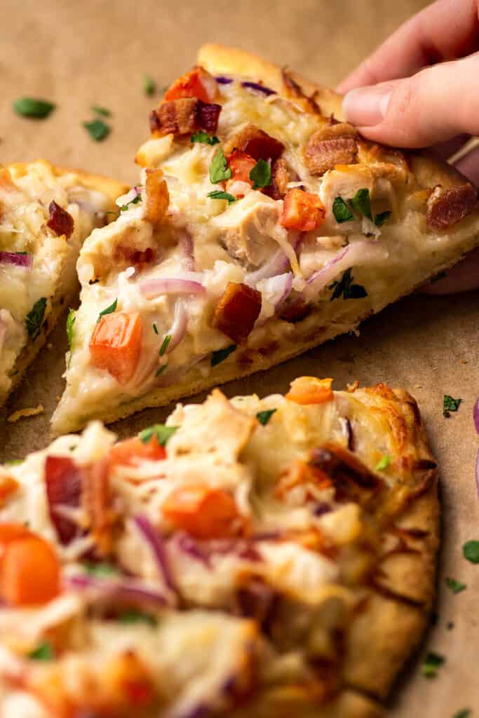 Slice of chicken bacon ranch pizza being picked up.