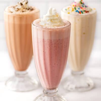 Strawberry, vanilla, and chocolate milkshake recipes in clear glasses.