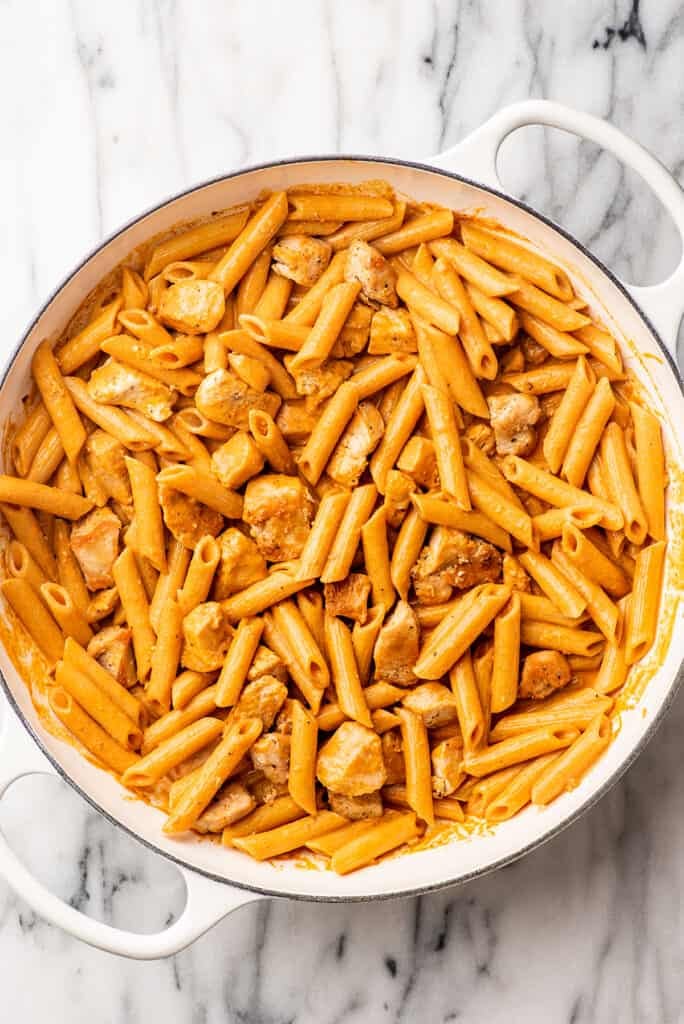 Penne alla vodka with chicken in a white pot.