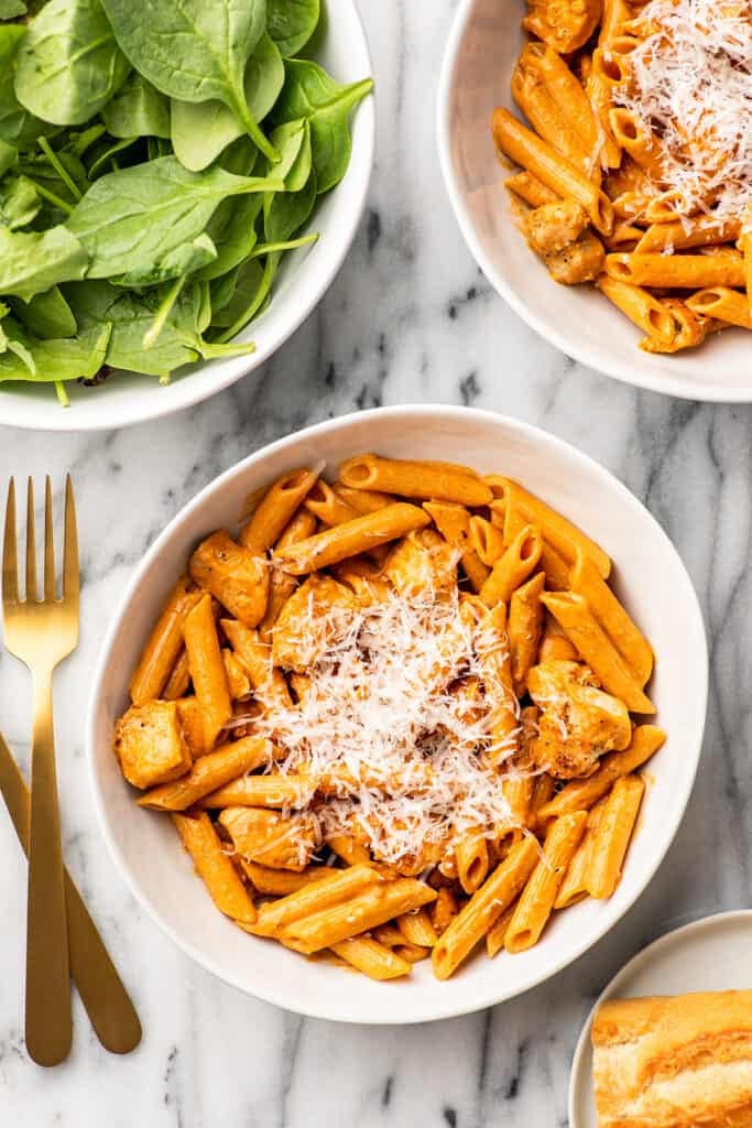Penne alla vodka with chicken in a white bowl.