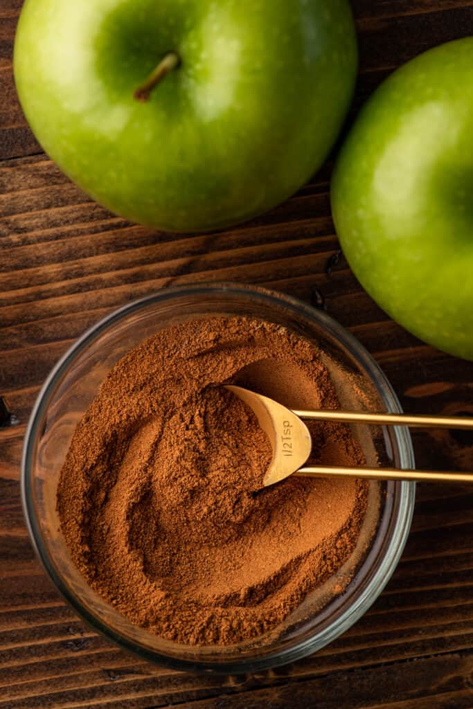 Apple pie spice in a bowl with a measuring spoon.