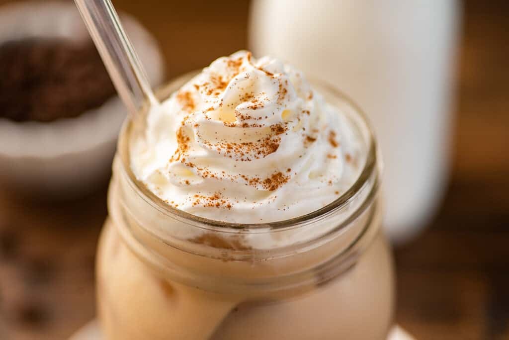 Iced dirty chai latte with cinnamon sprinkled on the top.