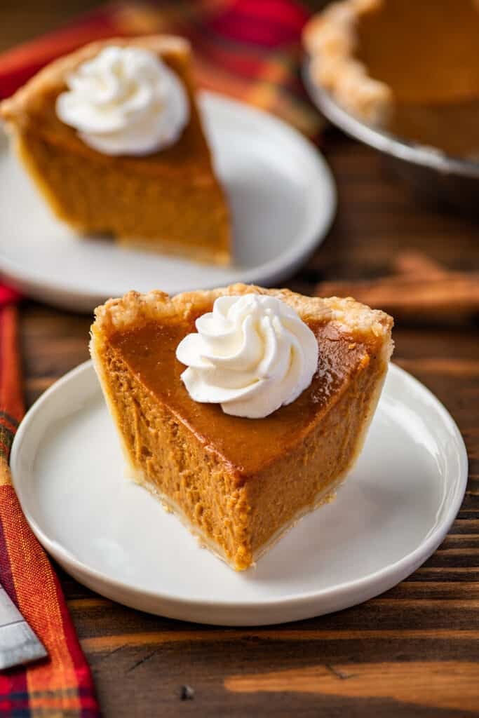 Slice of mini pumpkin pie with whipped cream on top.