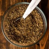 a bowl of homemade italian seasoning with a teaspoon