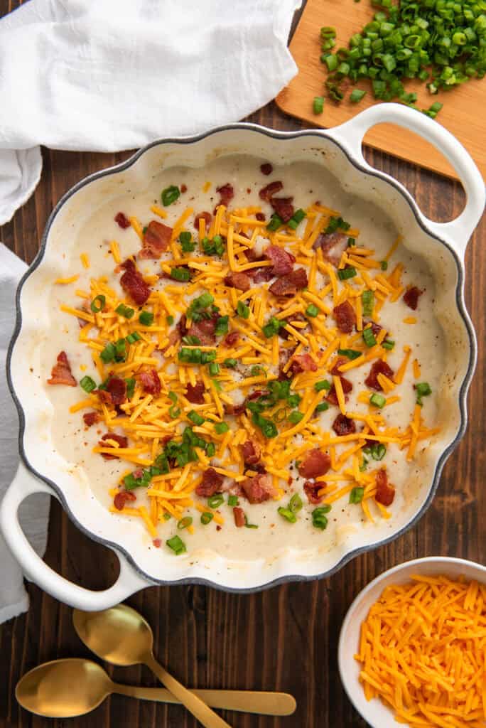 Baked potato soup in a white pot.