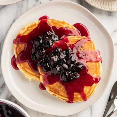 a plate of pancakes topped with blueberry syrup