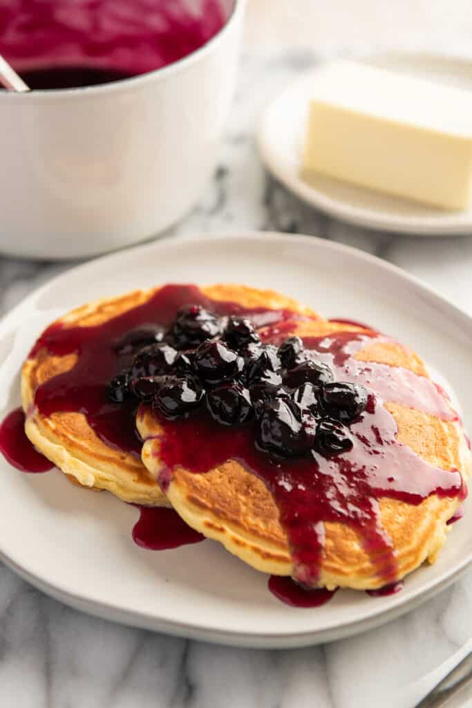 Pancakes on a plate with syrup made of blueberries.