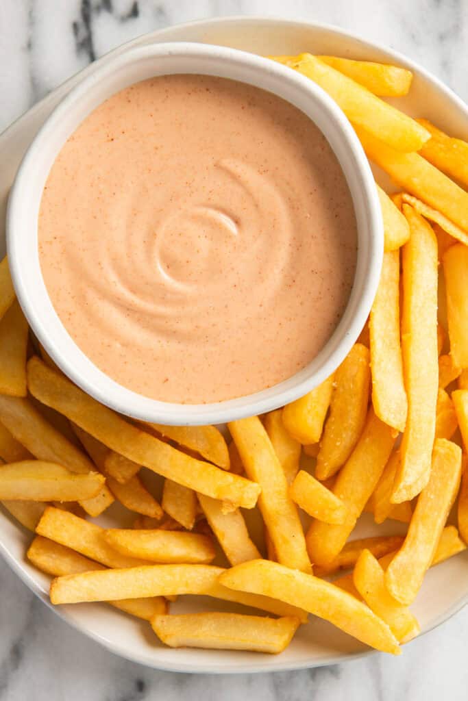 Fry sauce in a bowl with french fries around it.