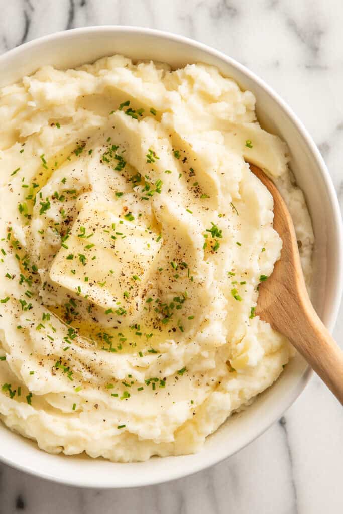 Close up of mashed potatoes in a bowl with butter on top