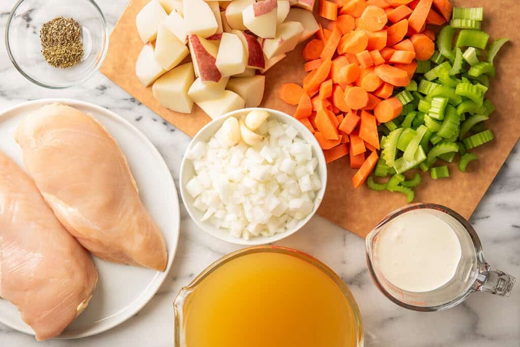 Ingredients for creamy chicken and potato soup on a counter.