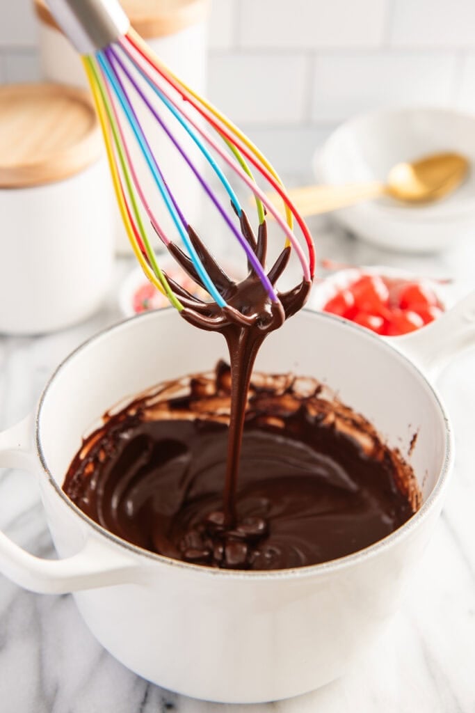 Hot fudge sauce dripping from a whisk
